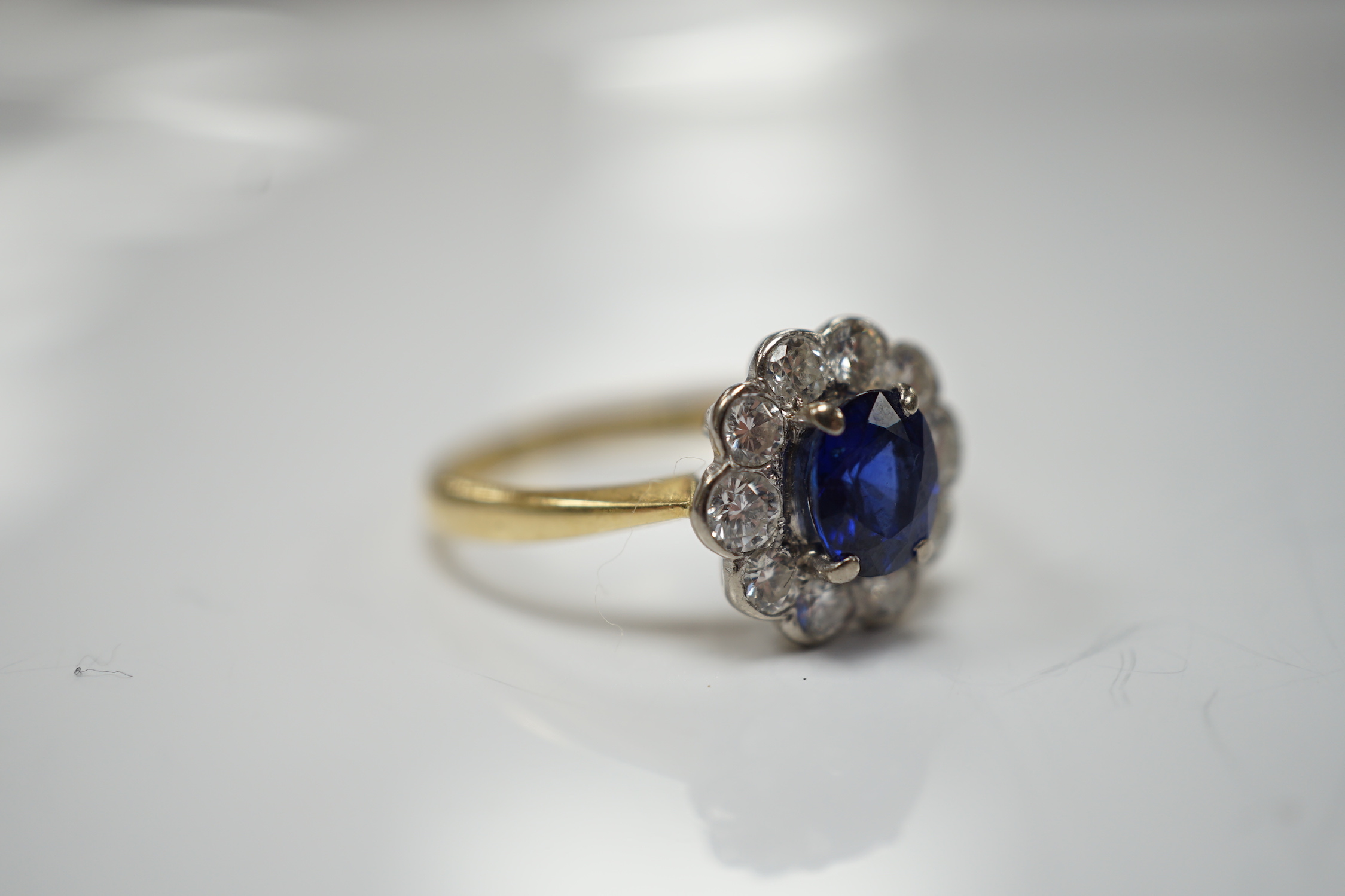 A modern 18ct gold, sapphire and diamond set circular cluster ring, size P/Q, gross weight 3.4 grams.